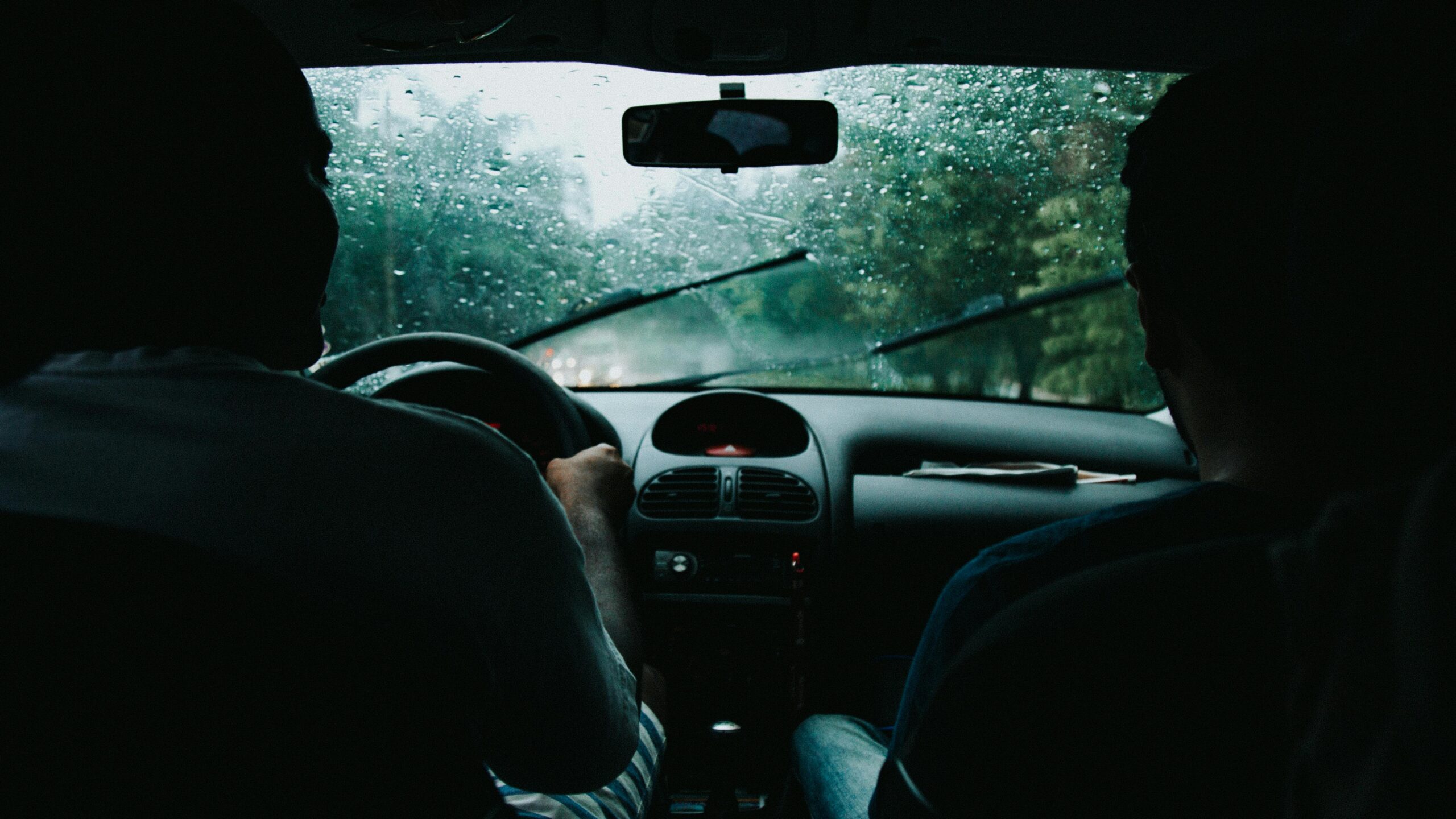 Image of two people in a car driving.